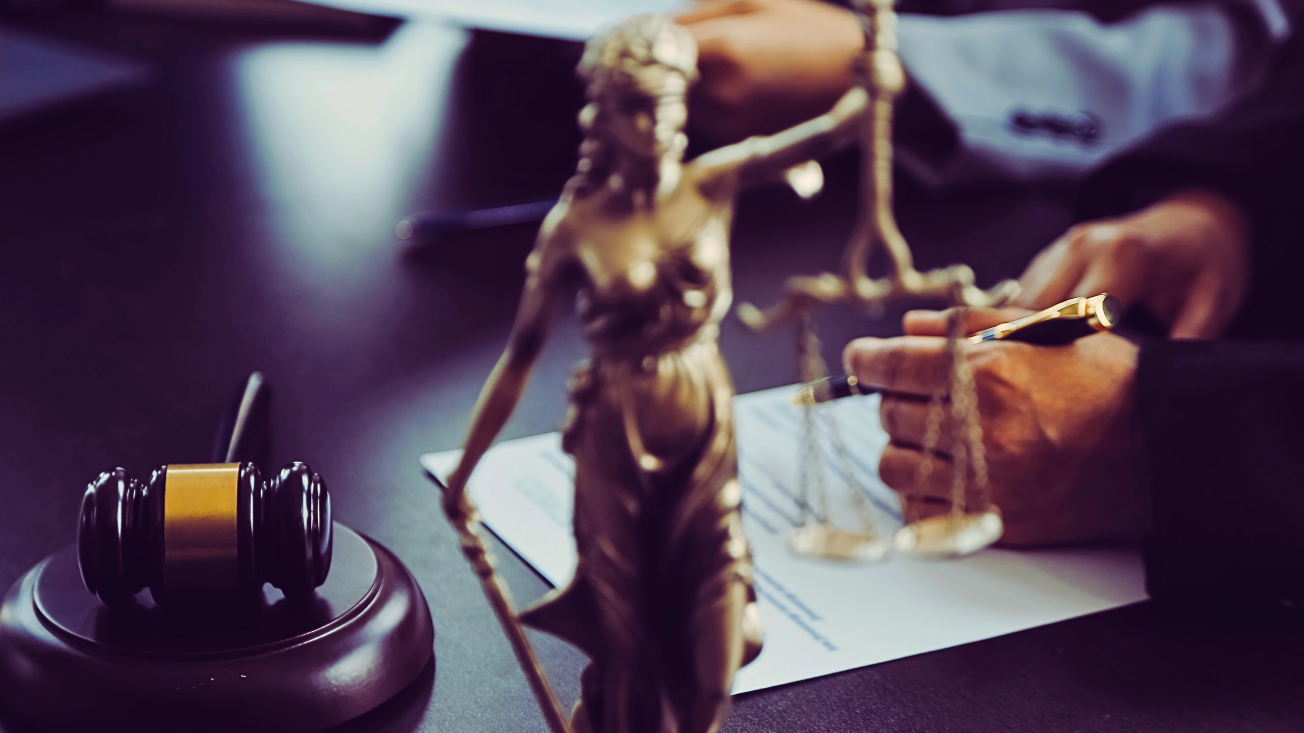 Lady Justice with a hand holding a pen on the background.