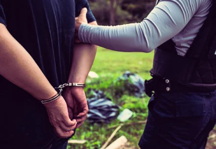 Guy being arrested by a police officer.