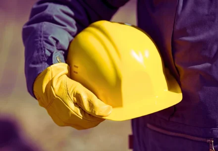 Laborer holding his yellow safety hat.