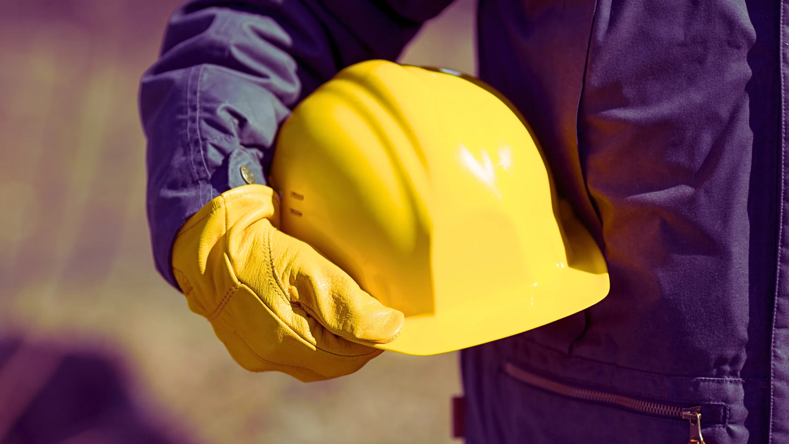 Laborer holding his yellow safety hat.