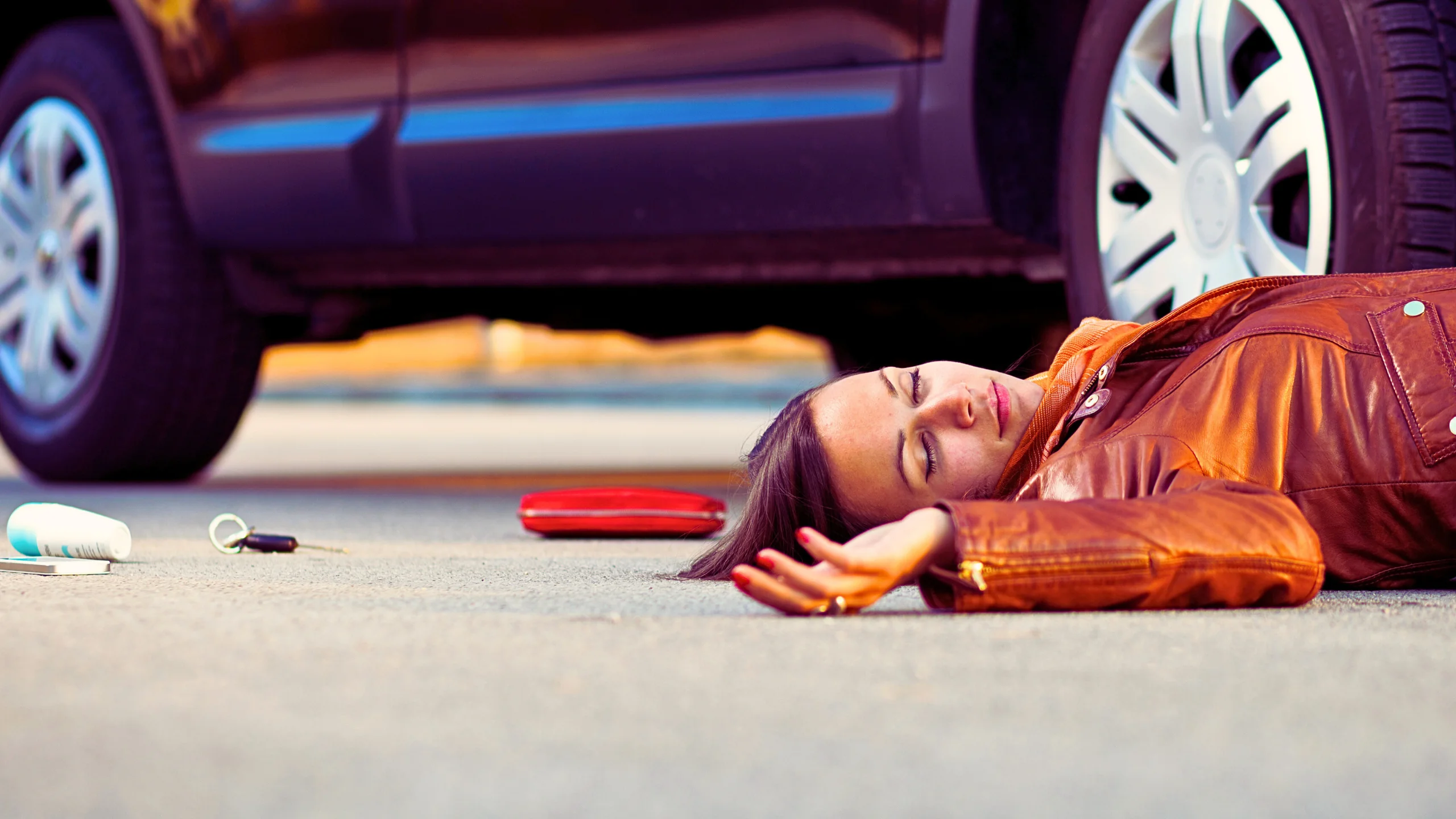 Woman in leather jacket hit by a car.