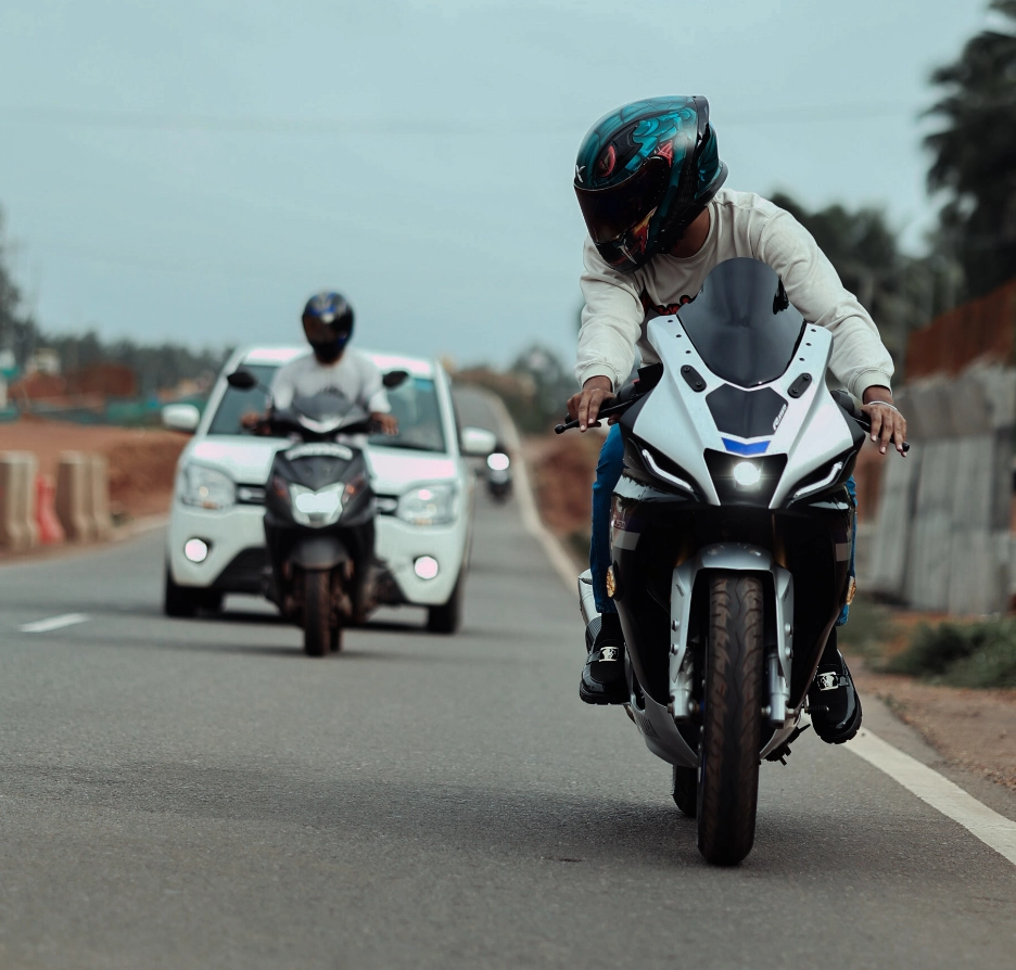 A motorcyclist leads traffic on a rural road.