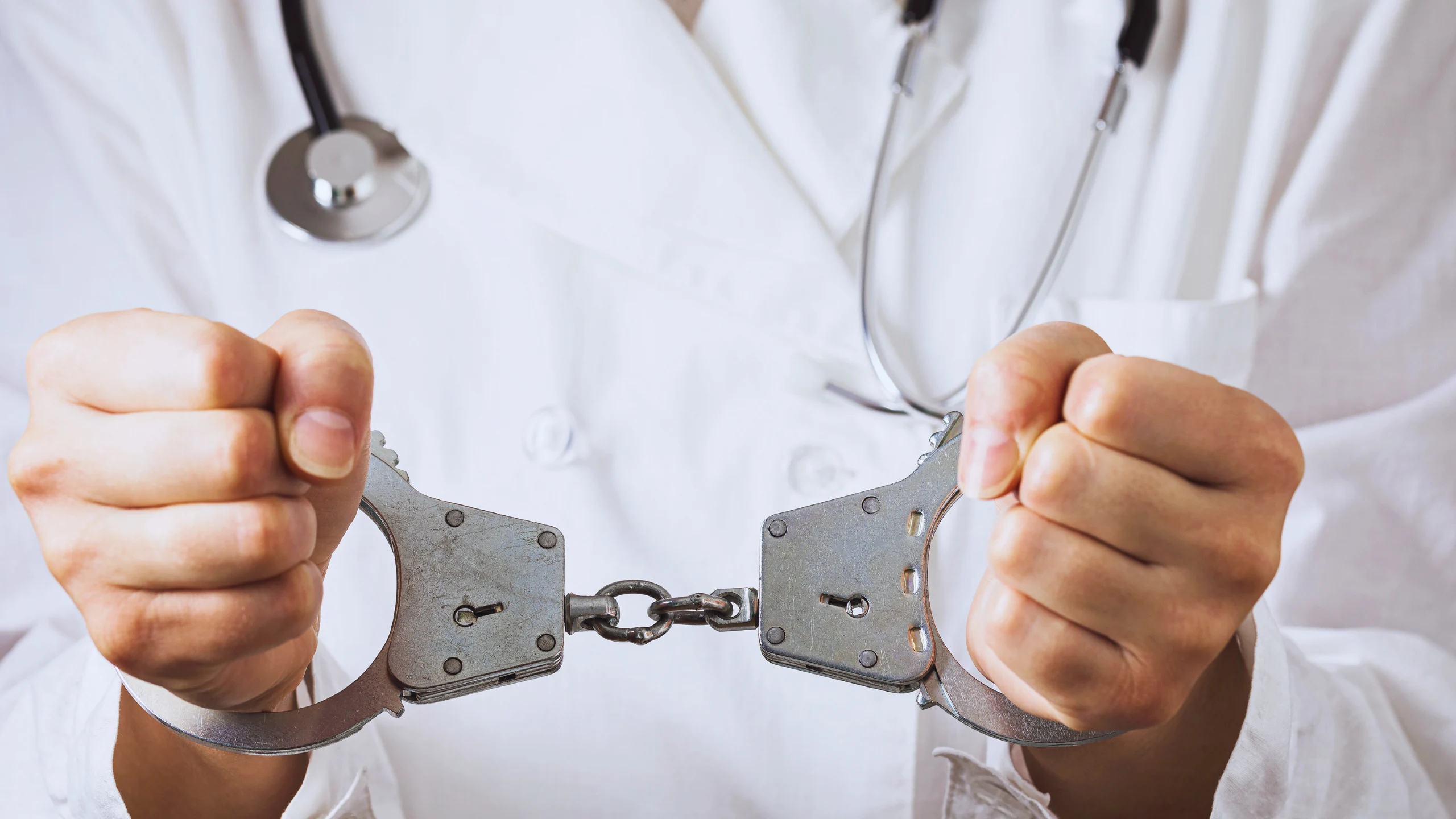 Plaintiff Established Continuous Treatment Doctrine in Medical Malpractice 1 Hands in a white doctor's coat holding handcuffs.