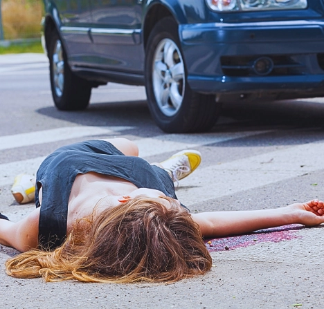 Woman lying on crosswalk after a car accident.