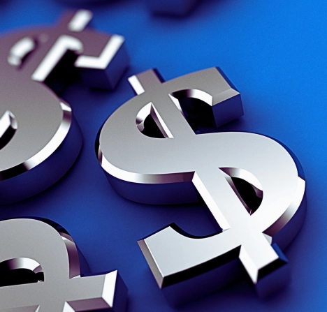several shiny, metallic dollar signs ($) scattered on a smooth blue surface.